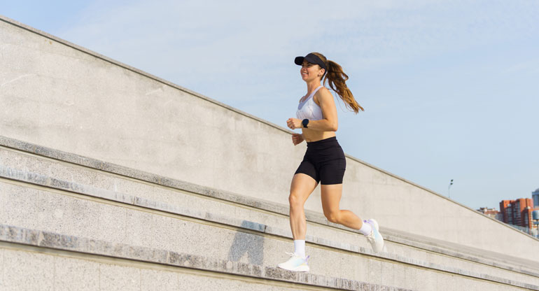 Frau joggt auf Treppenstufen - laufen auf Zeit